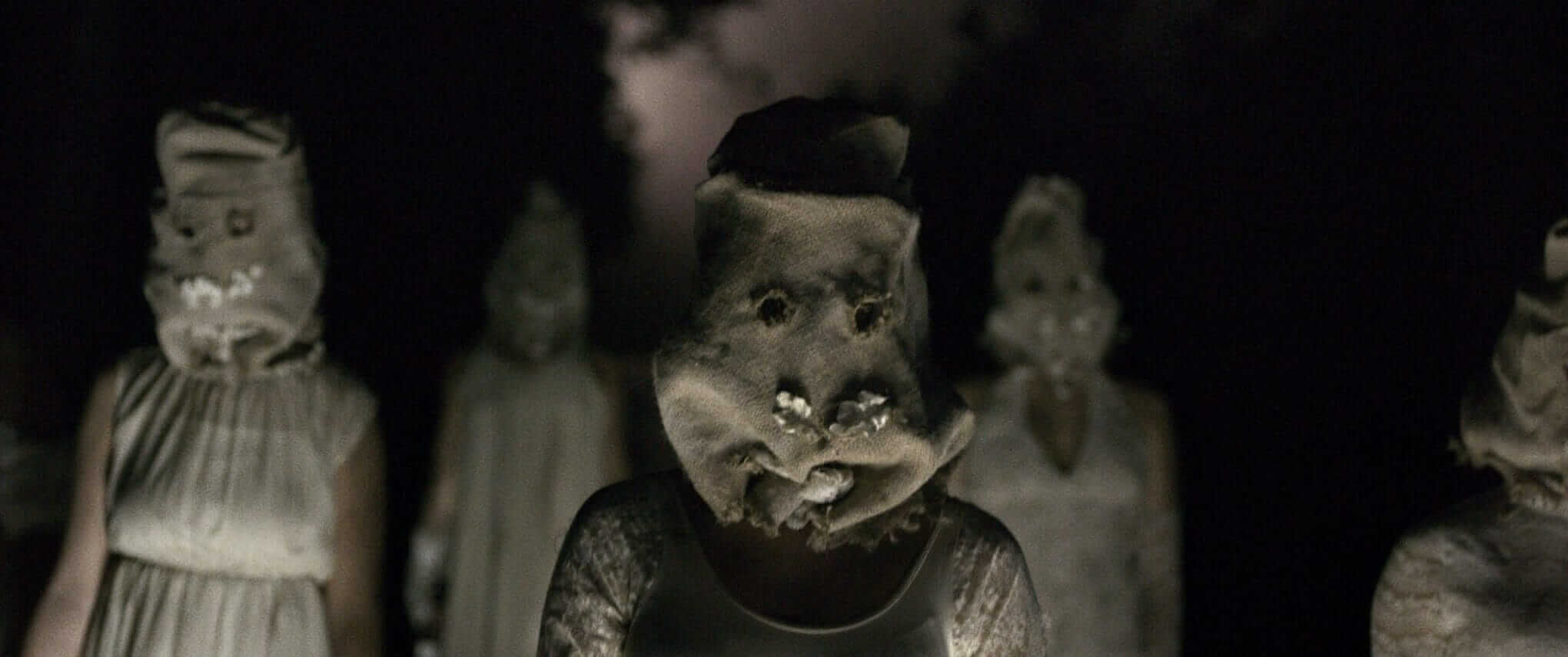 A still from The Toll of people wearing burlap sacks over heads