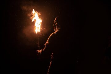 OUT OF DARKNESS (2024) Hunter looks cautiously into the dark with a torch